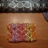 transparent kandi cuff made out of pink, purple, orange
      , and yellow beads