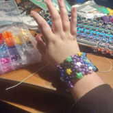 kandi cuff with stars as anchor beads and purple blue and black main 
      beads visible